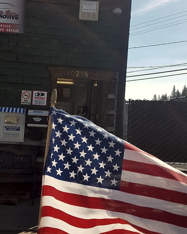 The shop's front door with a US flag in the foreground